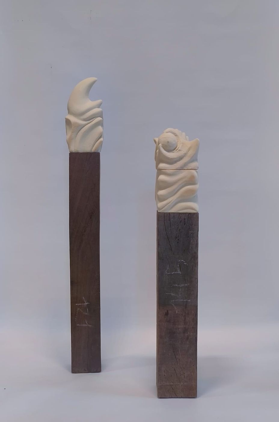Goodbye. Two white carved sculptures on wooden columns